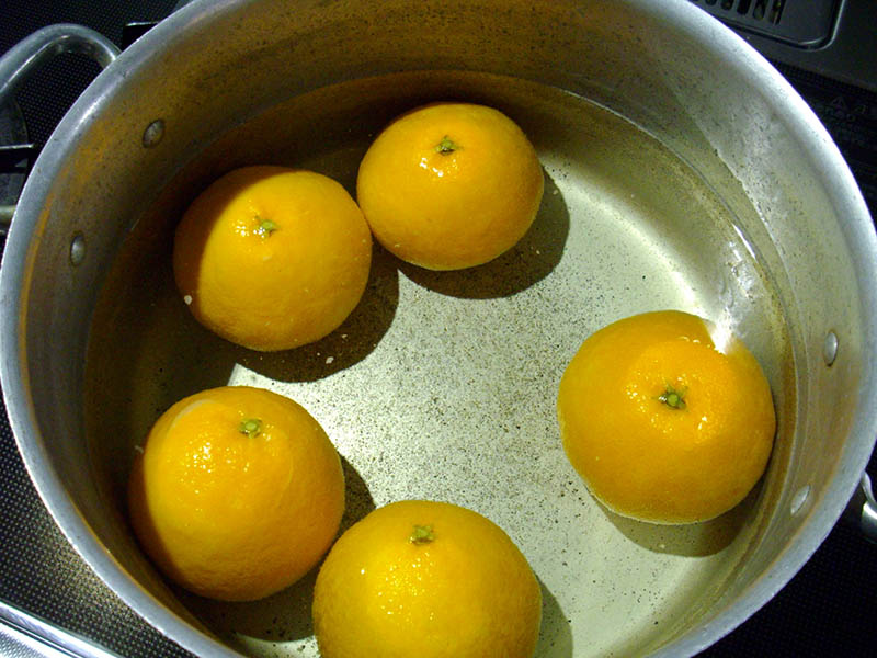 鍋にオレンジと水を入れて火にかけ、沸騰したらお湯を捨てる